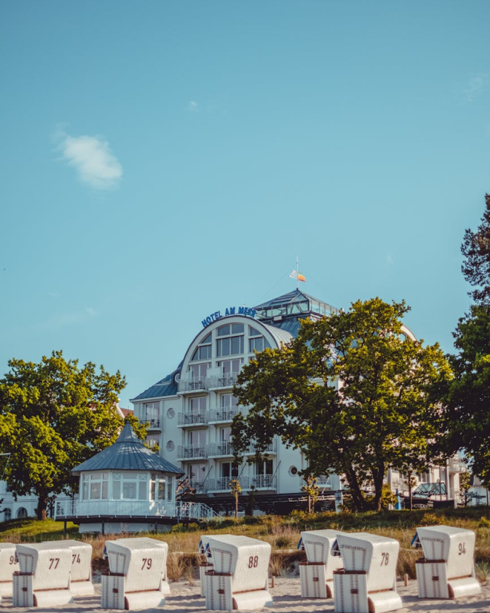 A hotel facade dappled in the shade of surrounding trees